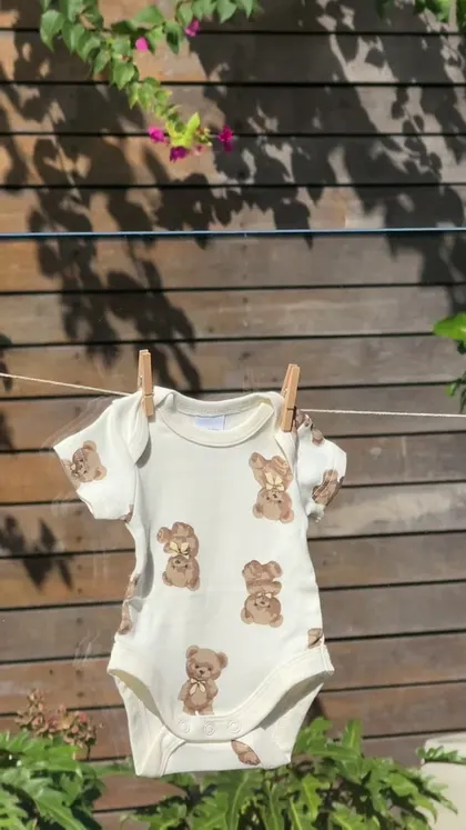 A keepsake photo from Jordan’s baby shower: a teddy-bear baby outfit in the garden